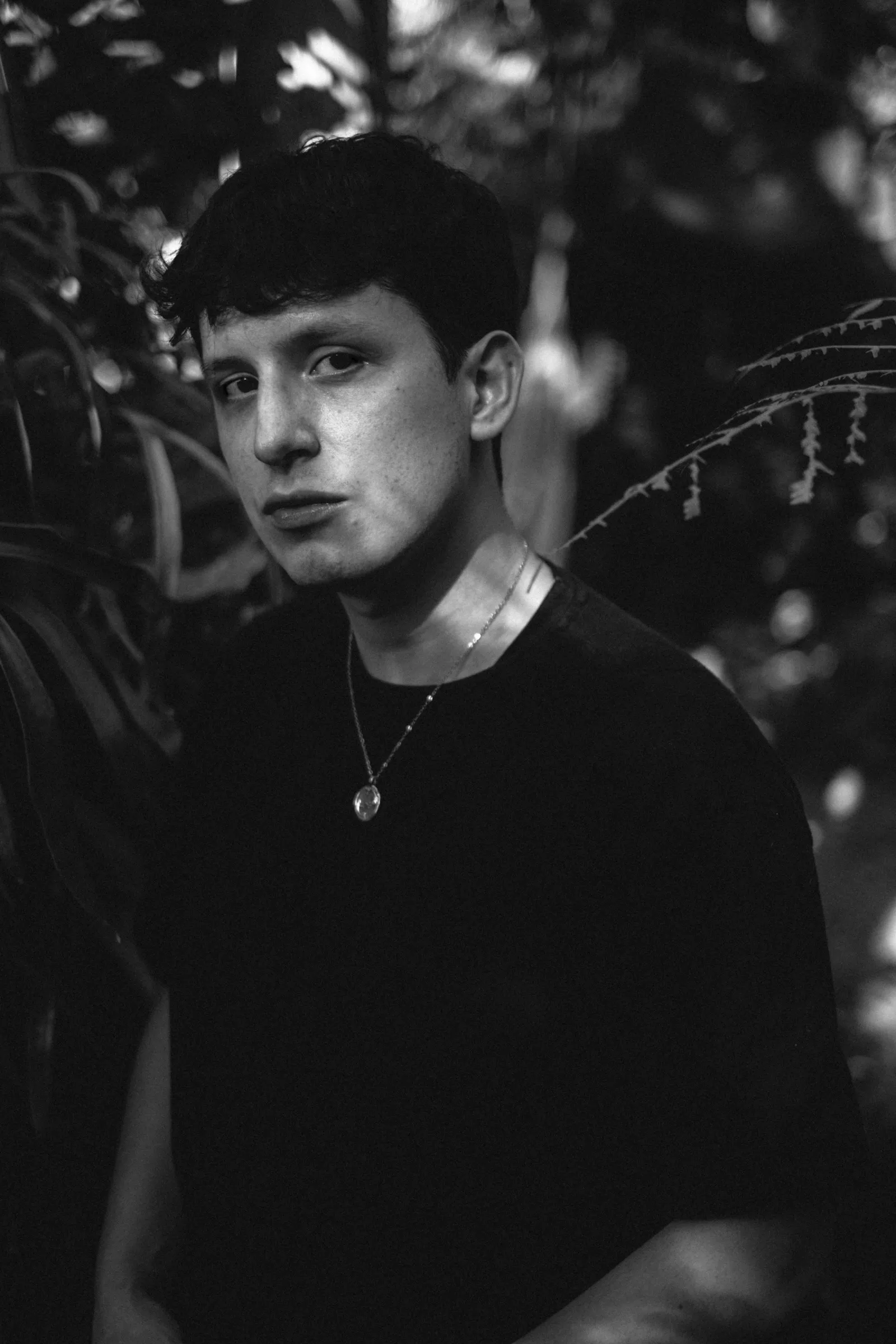 Retrato de Chéri entre plantas, en blanco y negro